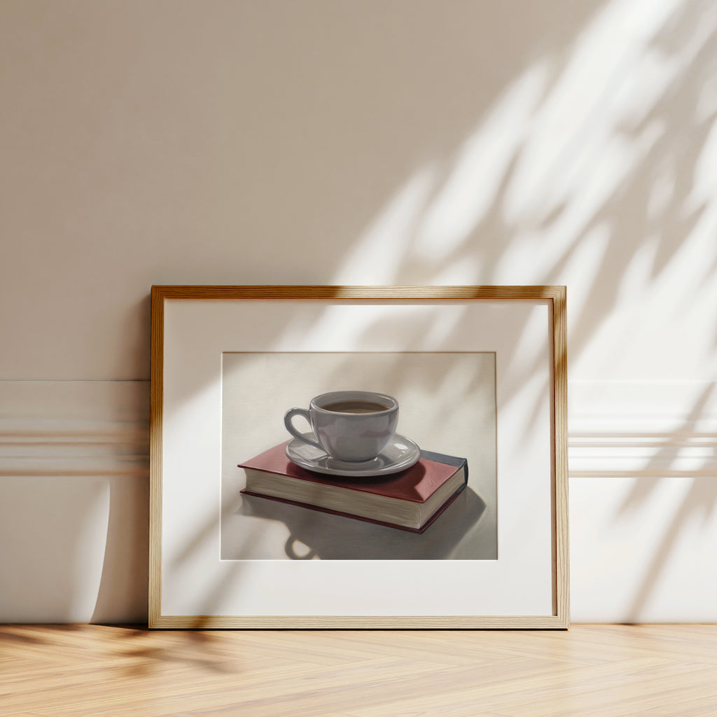 This artwork features a backlit coffee cup and saucer resting on top of a red book.