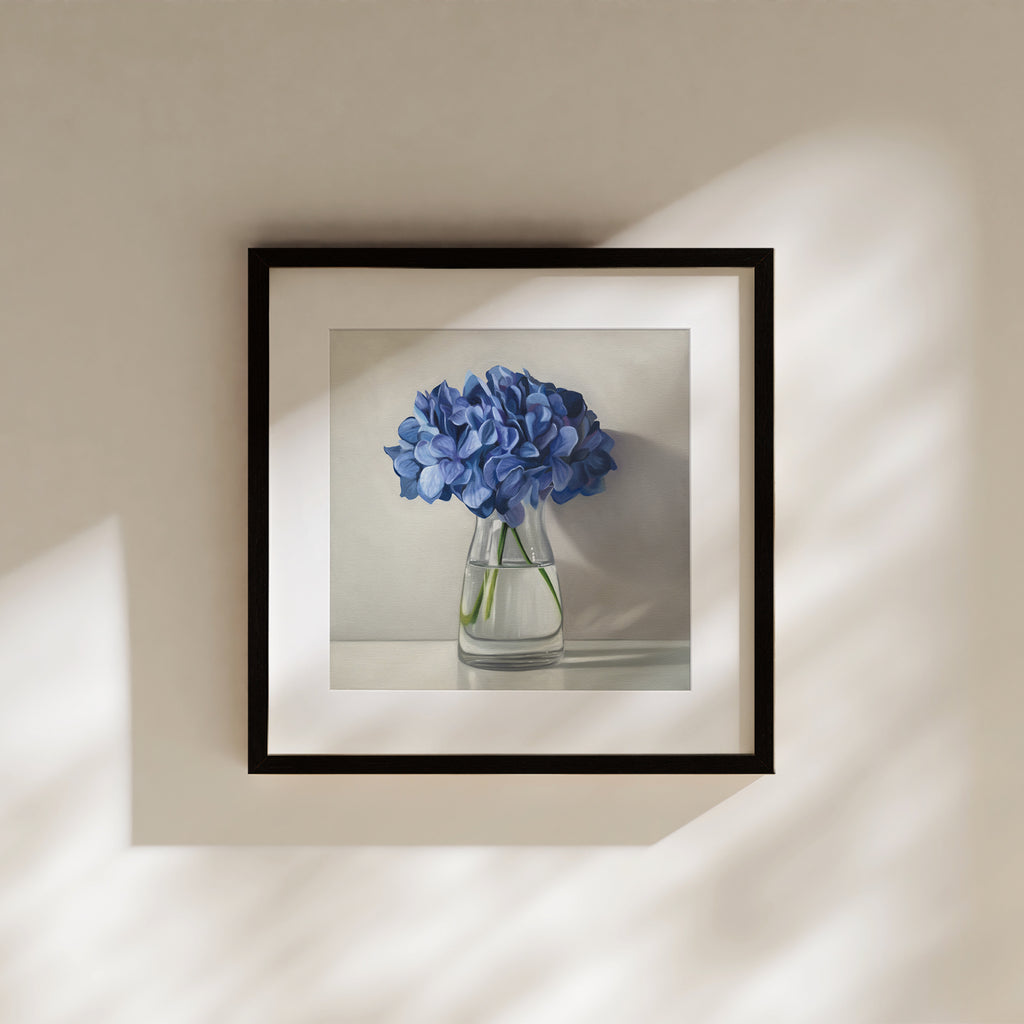 This artwork features a bouquet of blue hydrangeas in a glass vase with a light grey neutral background dramatic side-lighting.