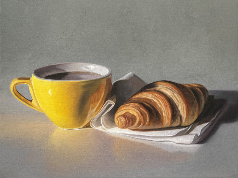 This artwork features a yellow cup of coffee and fresh croissant on a napkin.