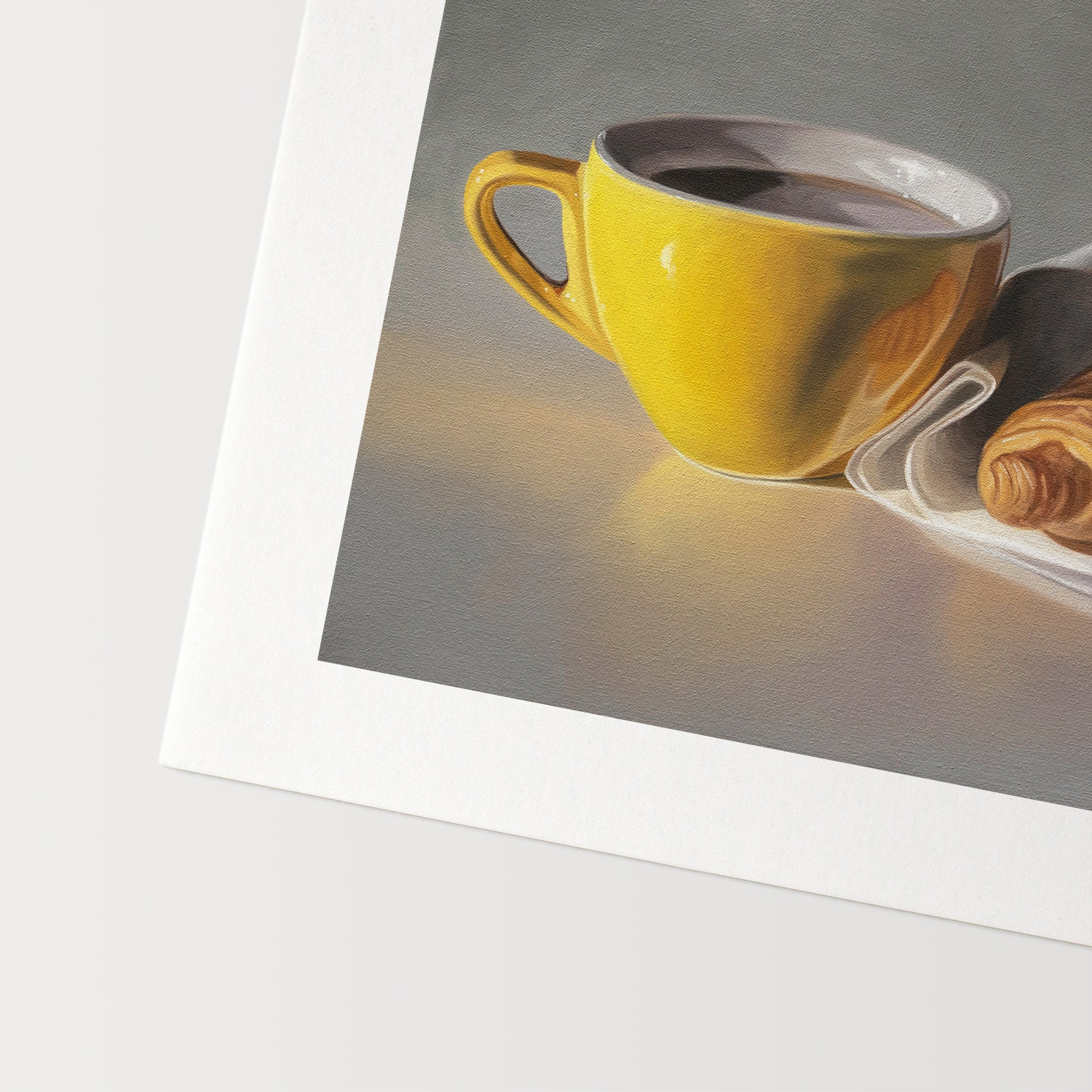 This artwork features a yellow cup of coffee and fresh croissant on a napkin.