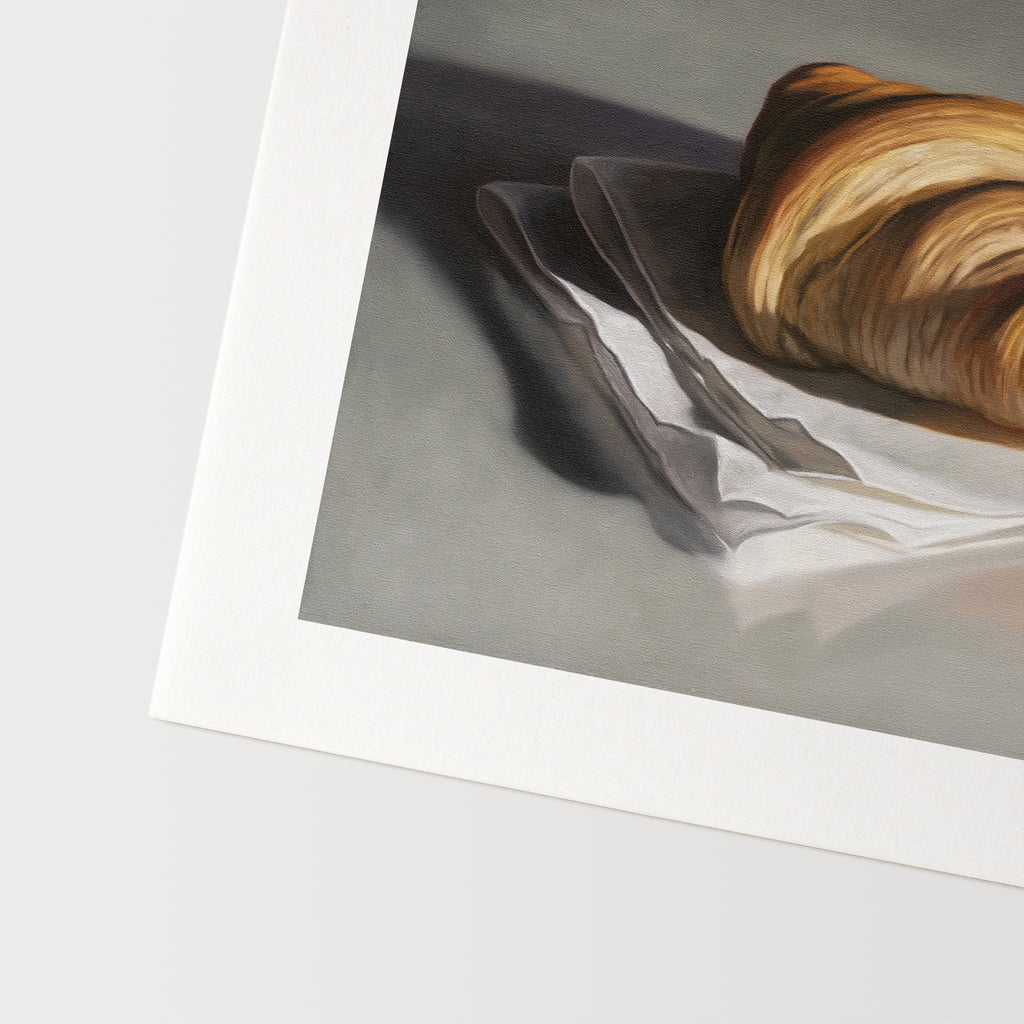 This artwork features a single freshly baked croissant resting on a napkin on a reflective surface.