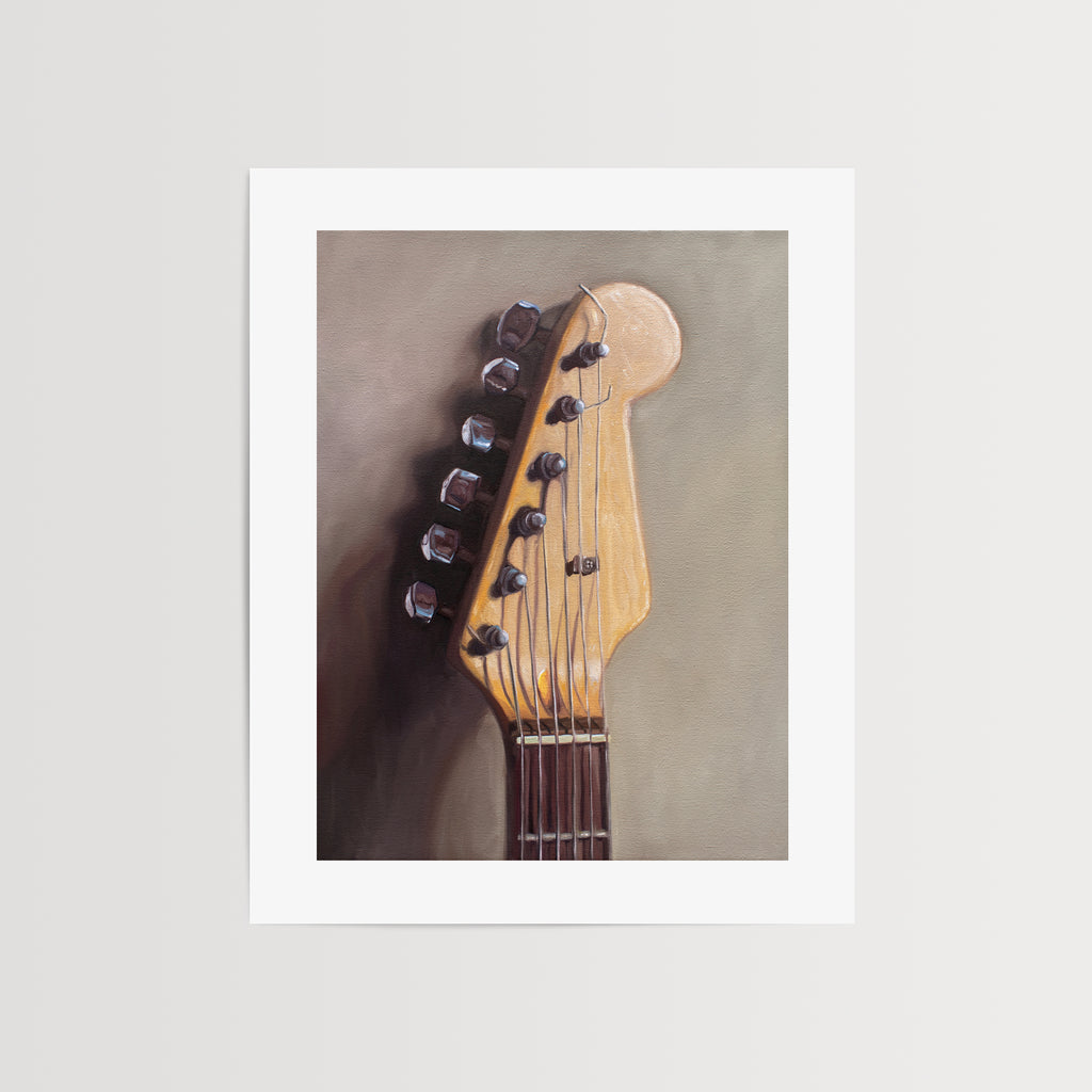 This artwork features an electric guitar head stock leaning on a warm grey surface with some nice dramatic lighting.