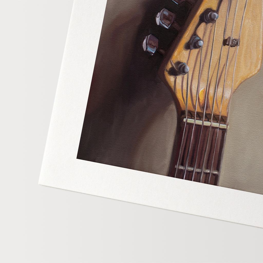 This artwork features an electric guitar head stock leaning on a warm grey surface with some nice dramatic lighting.