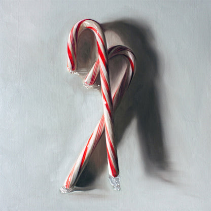 This artwork features a pair of candy canes resting on a light grey surface with dramatic side light.
