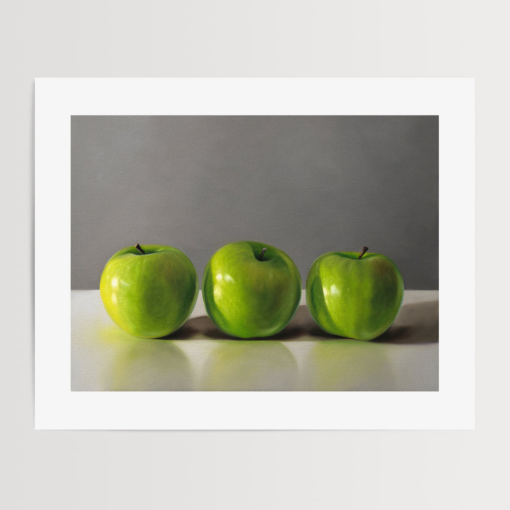 This artwork features a trio of bright green granny smith apples resting on a light, reflective surface with a neutral grey background.