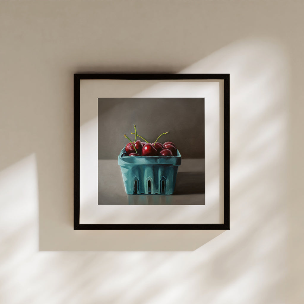This artwork features a turquoise blue basket of fresh red cherries.