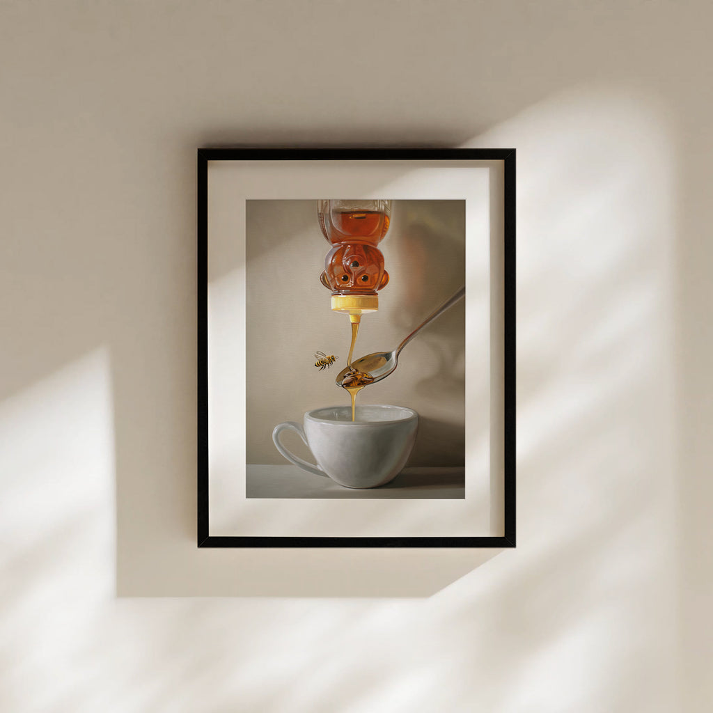 This artwork features a classic honey bear bottle turned upside down whilst golden honey spills into a spoon and cup of tea below.