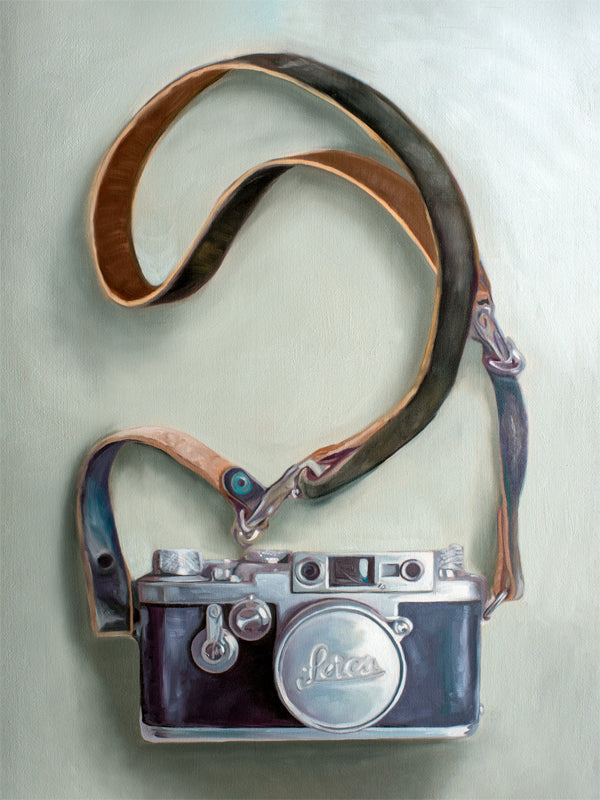 This artwork features a vintage Leica camera with a leather strap strategically layed out on a light surface.