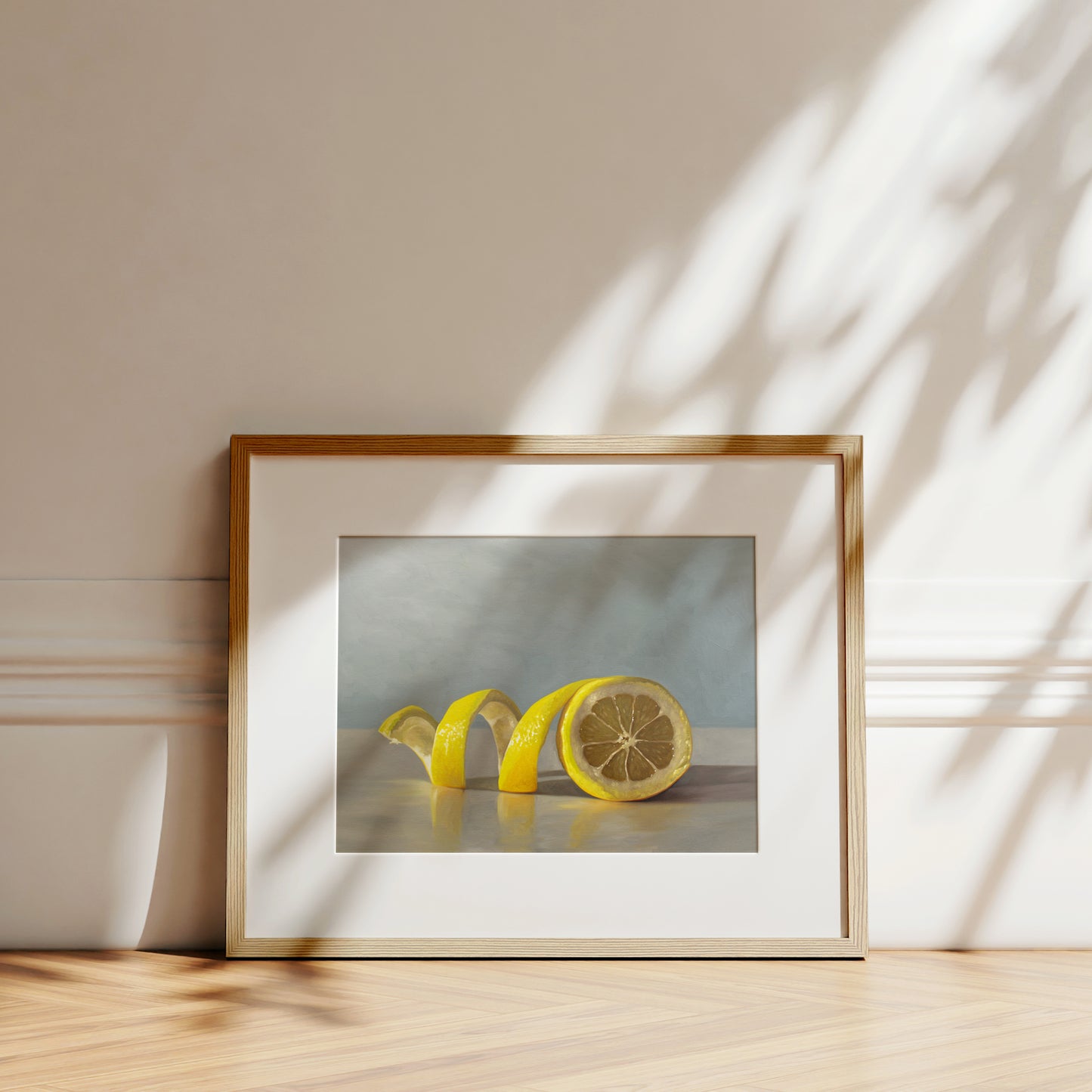 This artwork features a lemon half with its peeling spiraling out towards the left on a light, reflective surface and muted blue background.