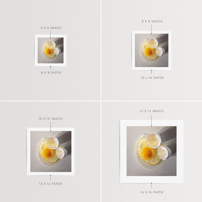 This artwork features a cracked egg resting on a light grey surface with some nice dramatic lighting.