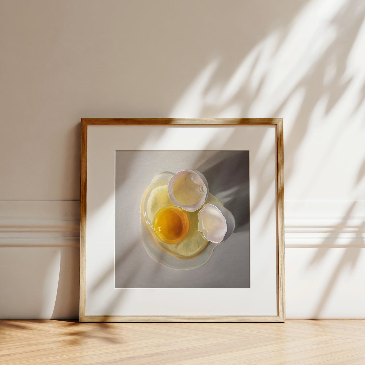 This artwork features a cracked egg resting on a light grey surface with some nice dramatic lighting.