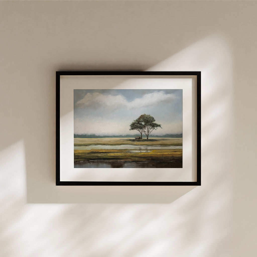 This artwork features an aged barn situated among a group of isolated trees in a marshland during summertime.