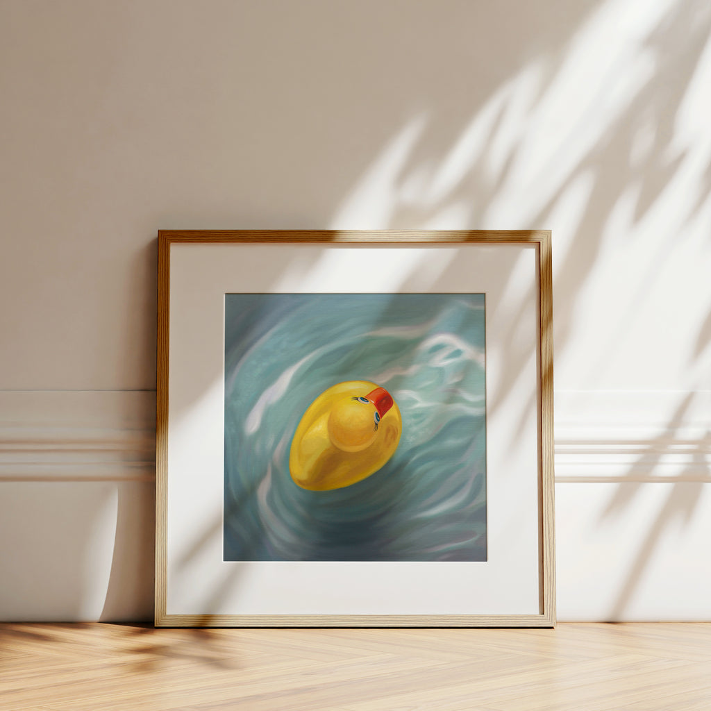 This artwork features a single rubber ducky floating in blue rippled water from above.