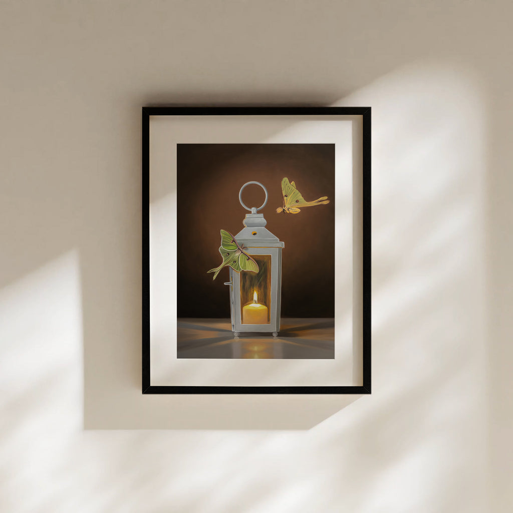 This artwork features a pair of Luna Moths attracted to a flame in a white candle lantern.