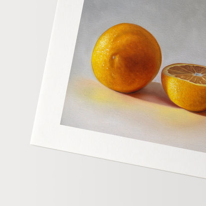 This artwork features a whole orange, half orange, and quarter slice of an orange resting on a light surface.