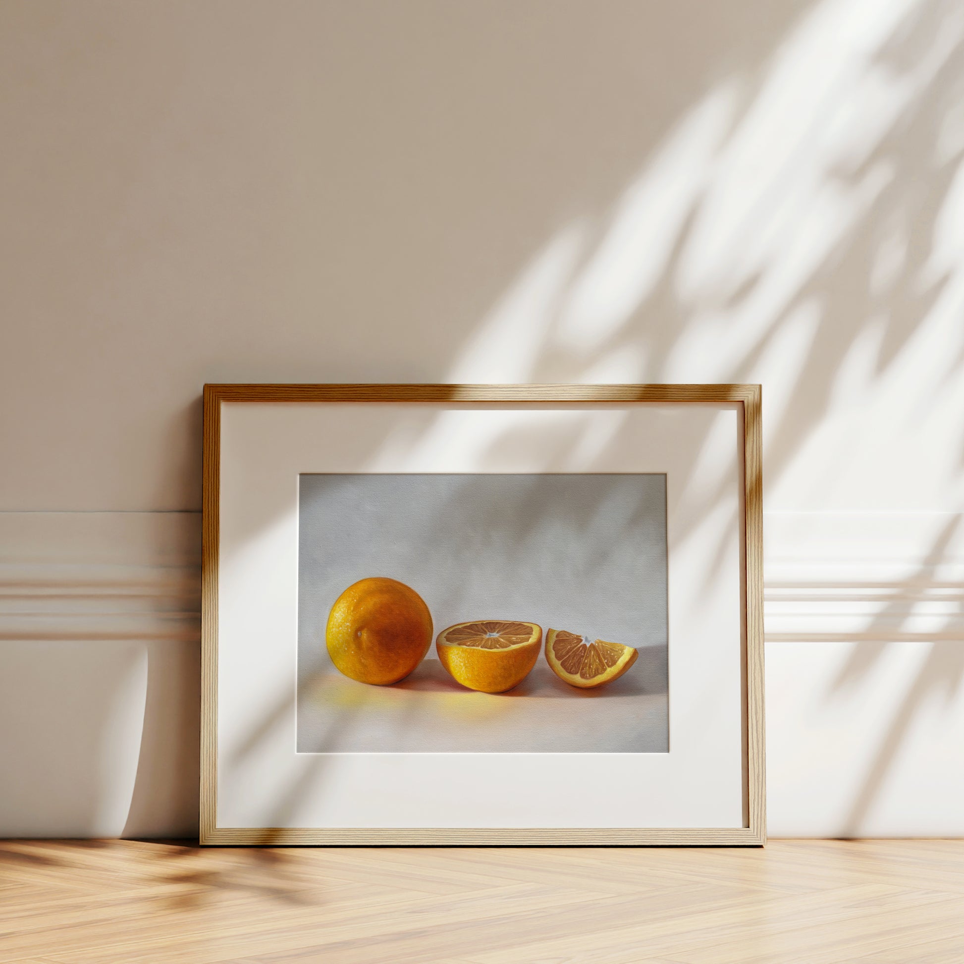 This artwork features a whole orange, half orange, and quarter slice of an orange resting on a light surface.