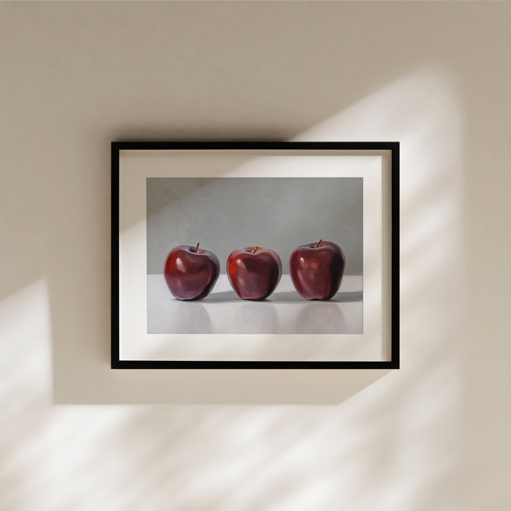 This artwork features a trio of Red Delicious apples resting on a light surface with a neutral grey background.