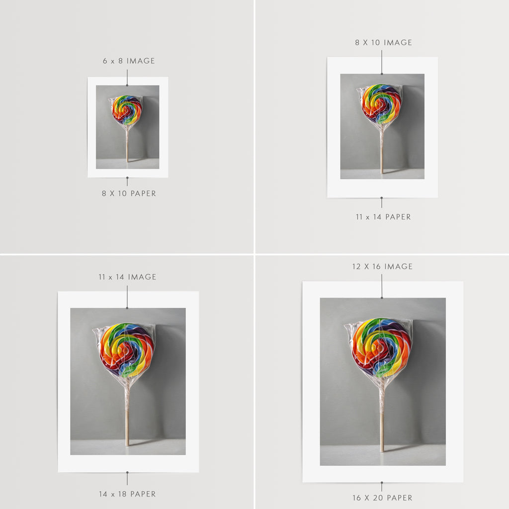 This artwork features a rainbow swirl lollipop leaning on a neutral grey wall with some nice dramatic lighting.