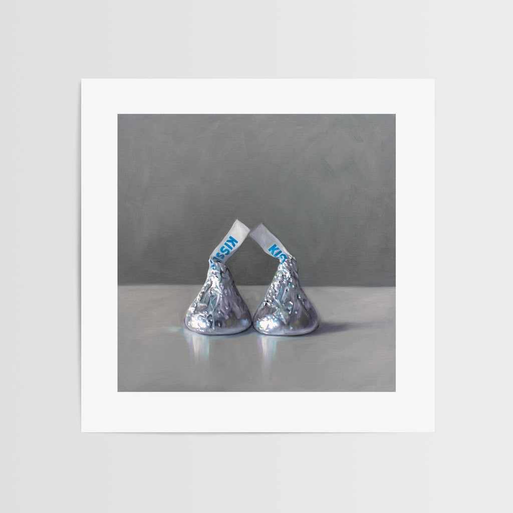 This artwork features a pair of classic milk chocolate drops on a reflective surface with a dark grey background.