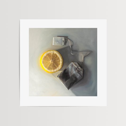This artwork features a slice of lemon laying next to a tea bag on a light grey surface with dramatic lighting and cast shadows.