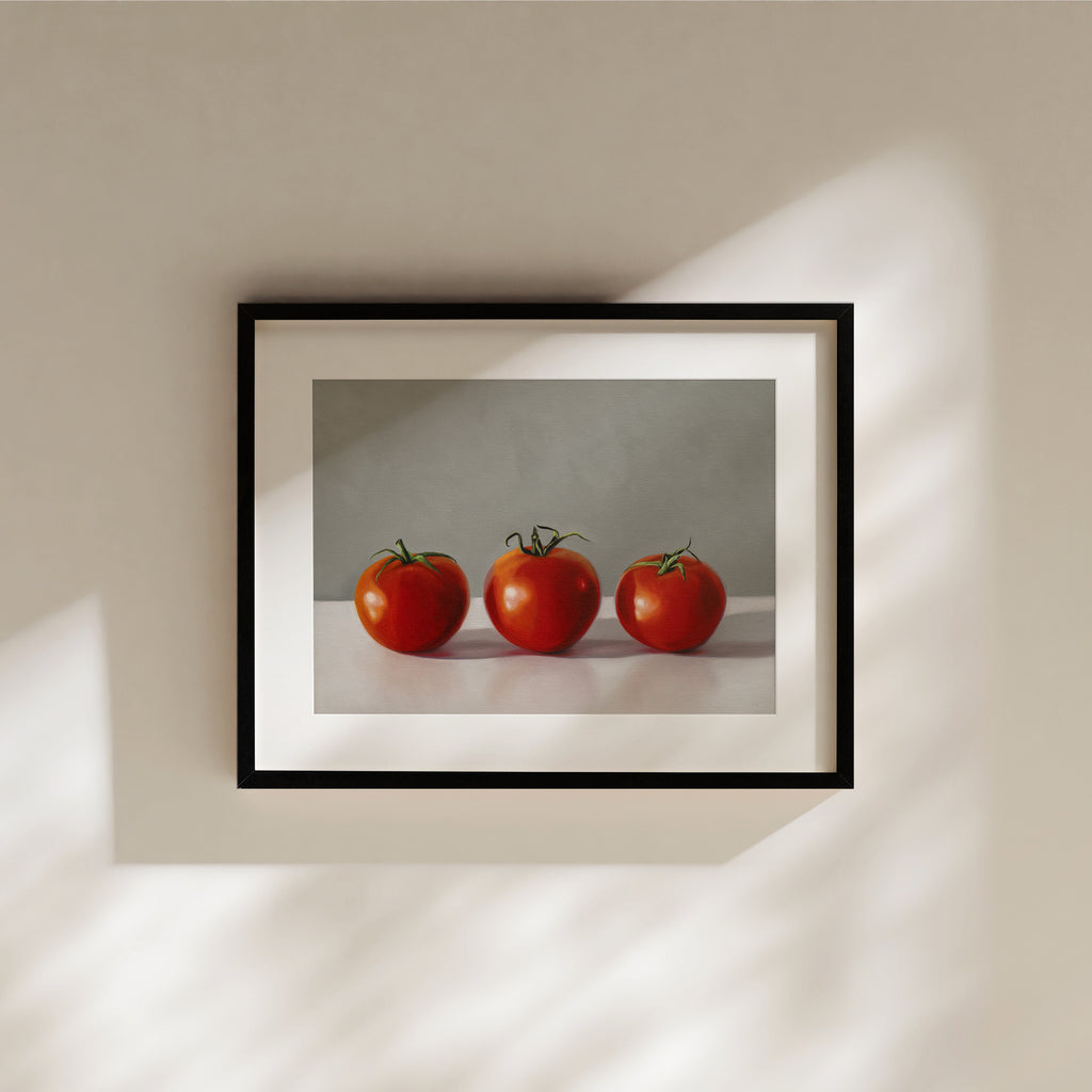 This artwork features a trio of bright red tomatoes resting on a light, reflective surface and a neutral backdrop.
