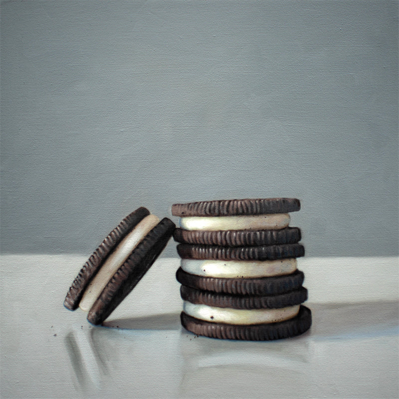 This artwork features a trio of Oreos on a light, reflective surface with dramatic lighting and cast shadows.