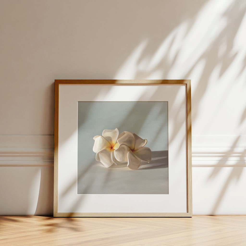 This artwork features a pair of white plumeria blossoms resting on a light bluegrey surface.