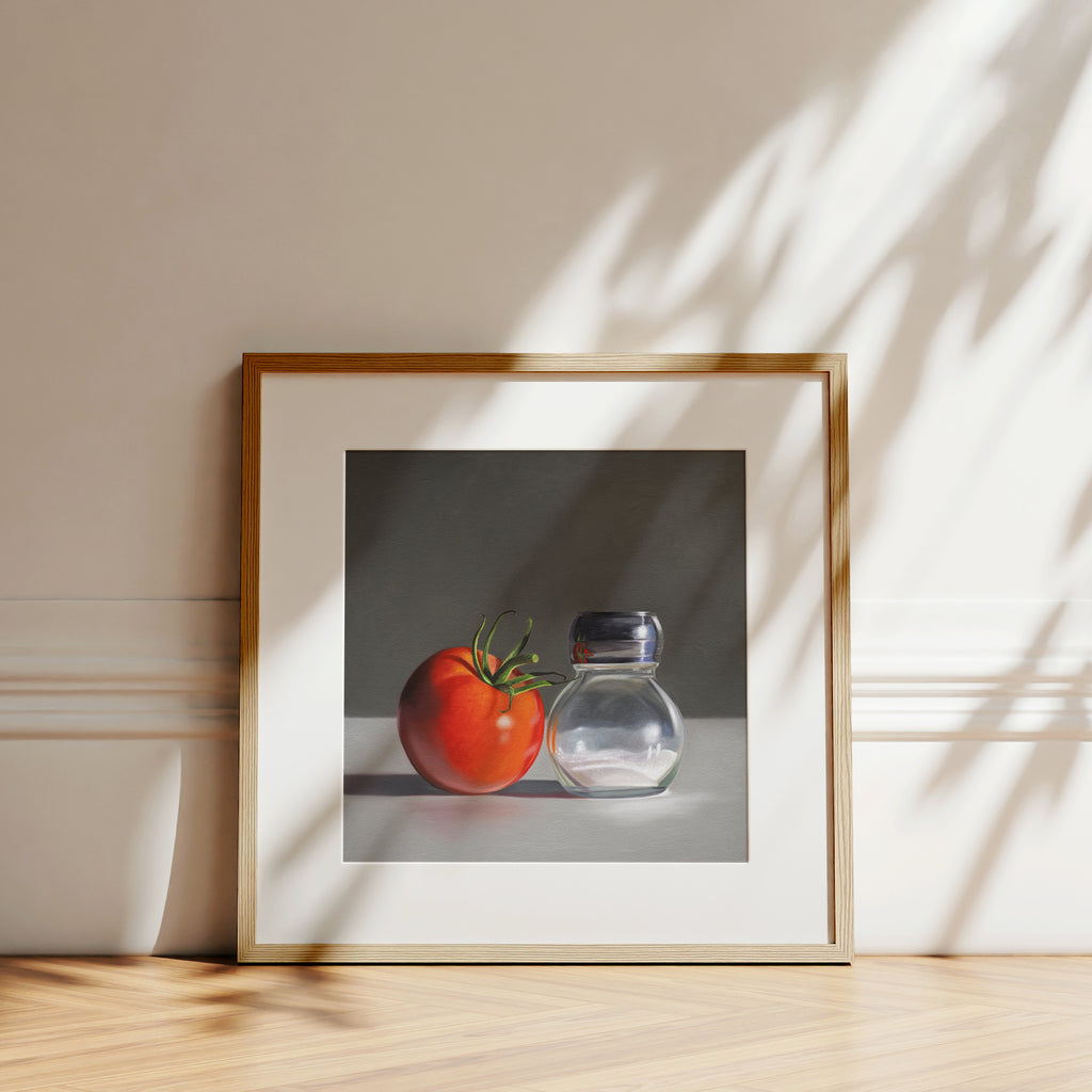 This artwork features a single fresh garden tomato situated by a reflective salt shaker.