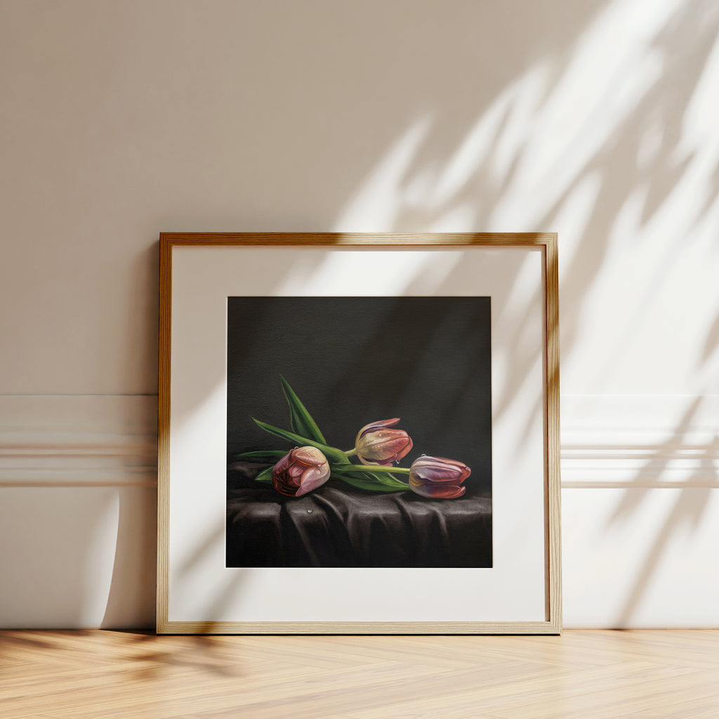 This artwork features a trio of dew drop tulips resting on draped dark satin fabric.