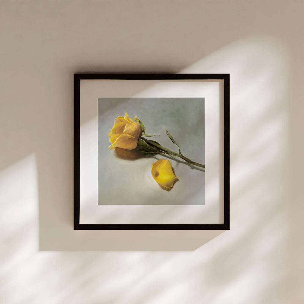 This artwork features a single yellow rose and petal laying on its side.