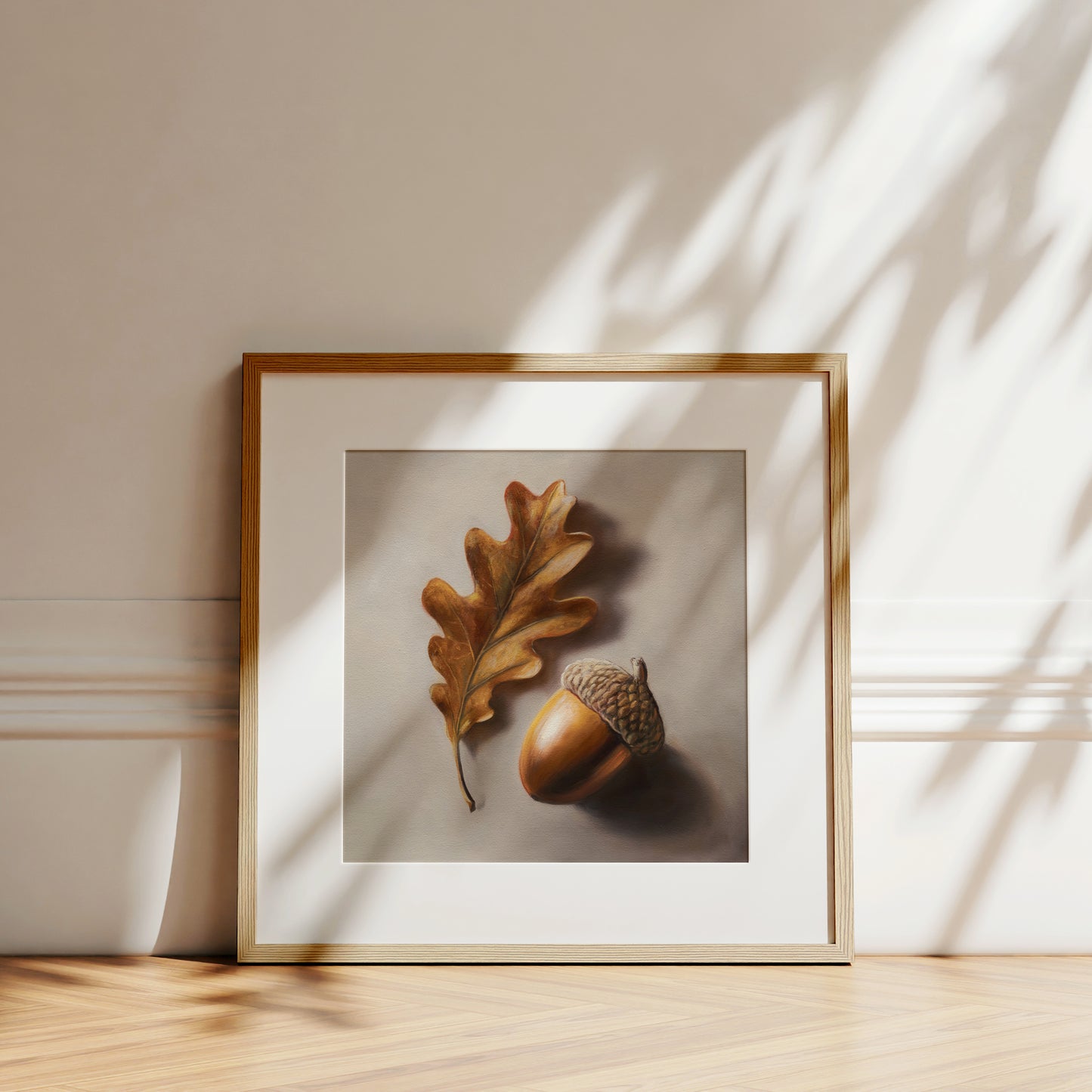 Framed fine art print of a realistic brown oak leaf and acorn on a light background.