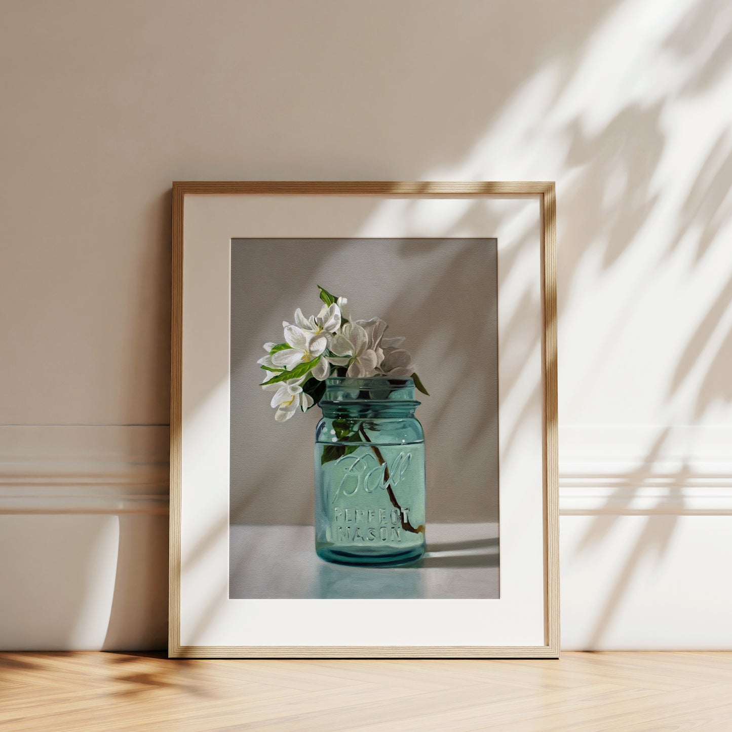 Fine art print of white apple blossoms in a vintage blue Ball Perfect Mason jar, framed in light wood.
