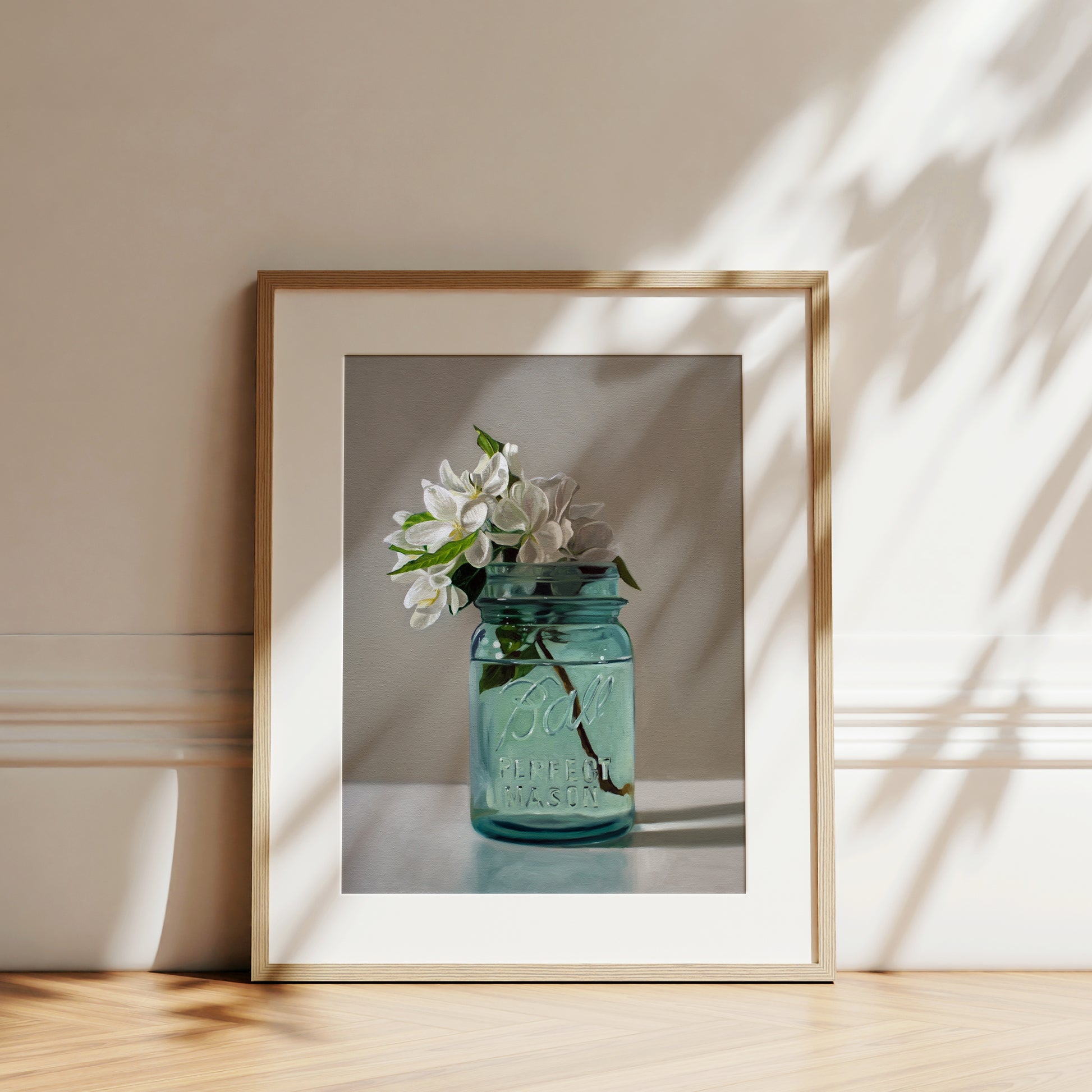 Fine art print of white apple blossoms in a vintage blue Ball Perfect Mason jar, framed in light wood.