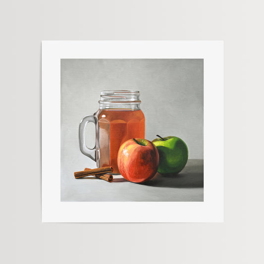 Apple Cider Fine Art Print by Lauren Pretorius: a glass jar filled with apple cider and two apples, with cinnamon sticks lying in front.