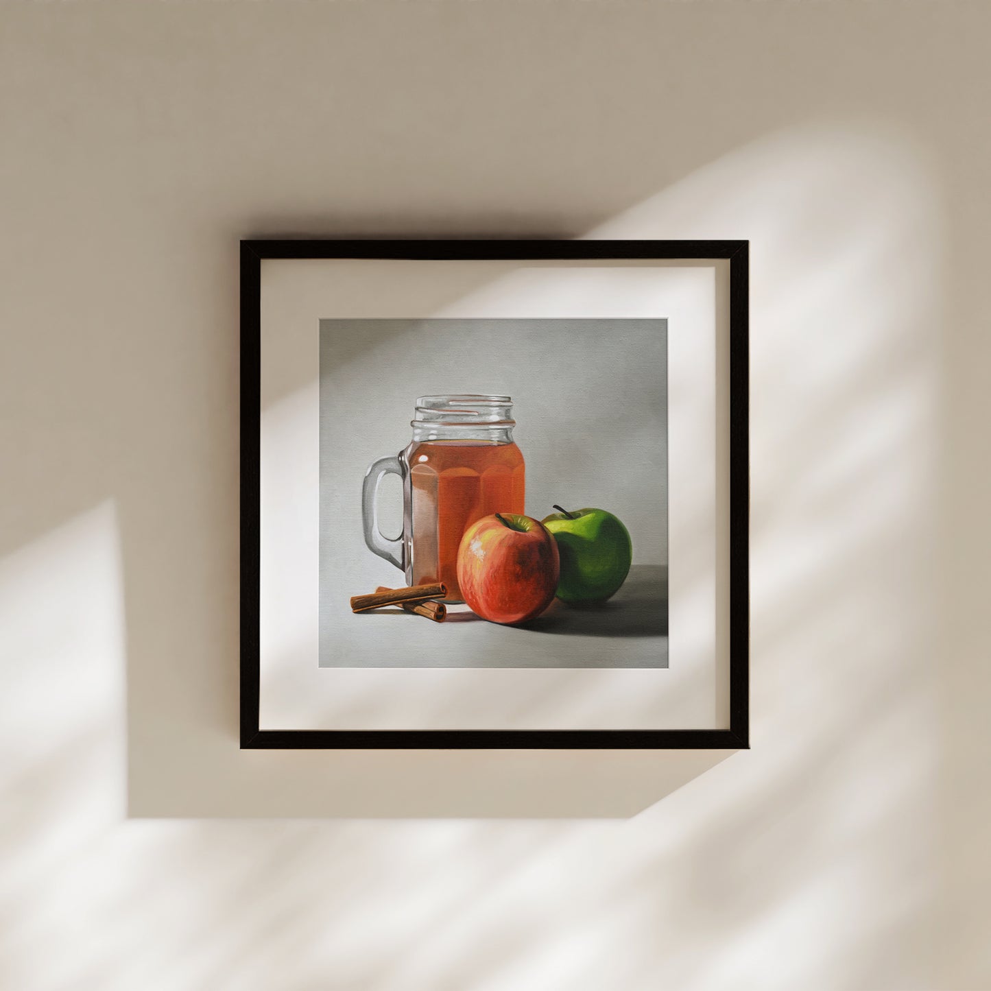 Framed fine art print of a glass of apple cider, red and green apples, and cinnamon sticks.