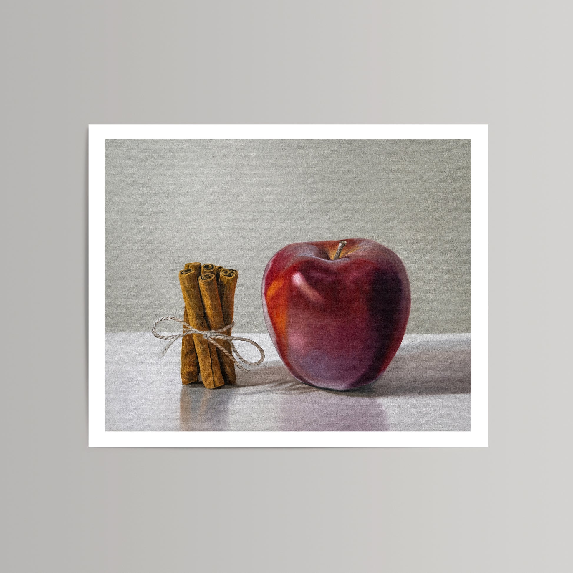 Vibrant red apple and tied cinnamon sticks on a white background, a fine art print.