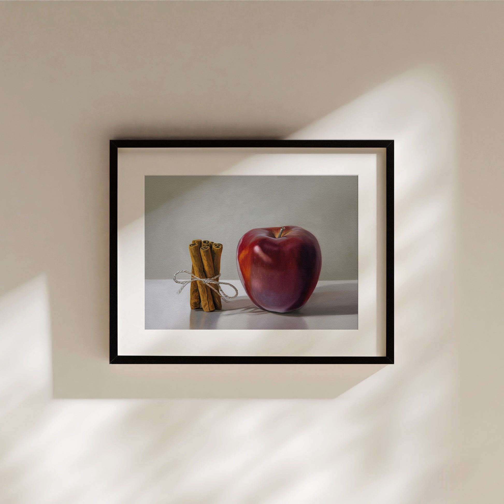 Framed "Apple Cinnamon" fine art print featuring a vibrant red apple and tied cinnamon sticks.