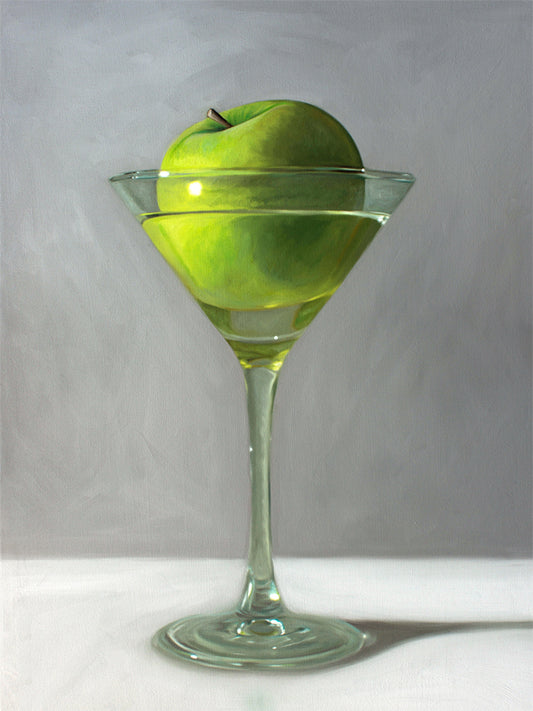 Apple Martini Fine Art Print by Lauren Pretorius: a whimsical take on the traditional Apple Martini cocktail. A single granny smith apple rests inside a martini glass on a light, reflective surface with dramatic light and shadows.