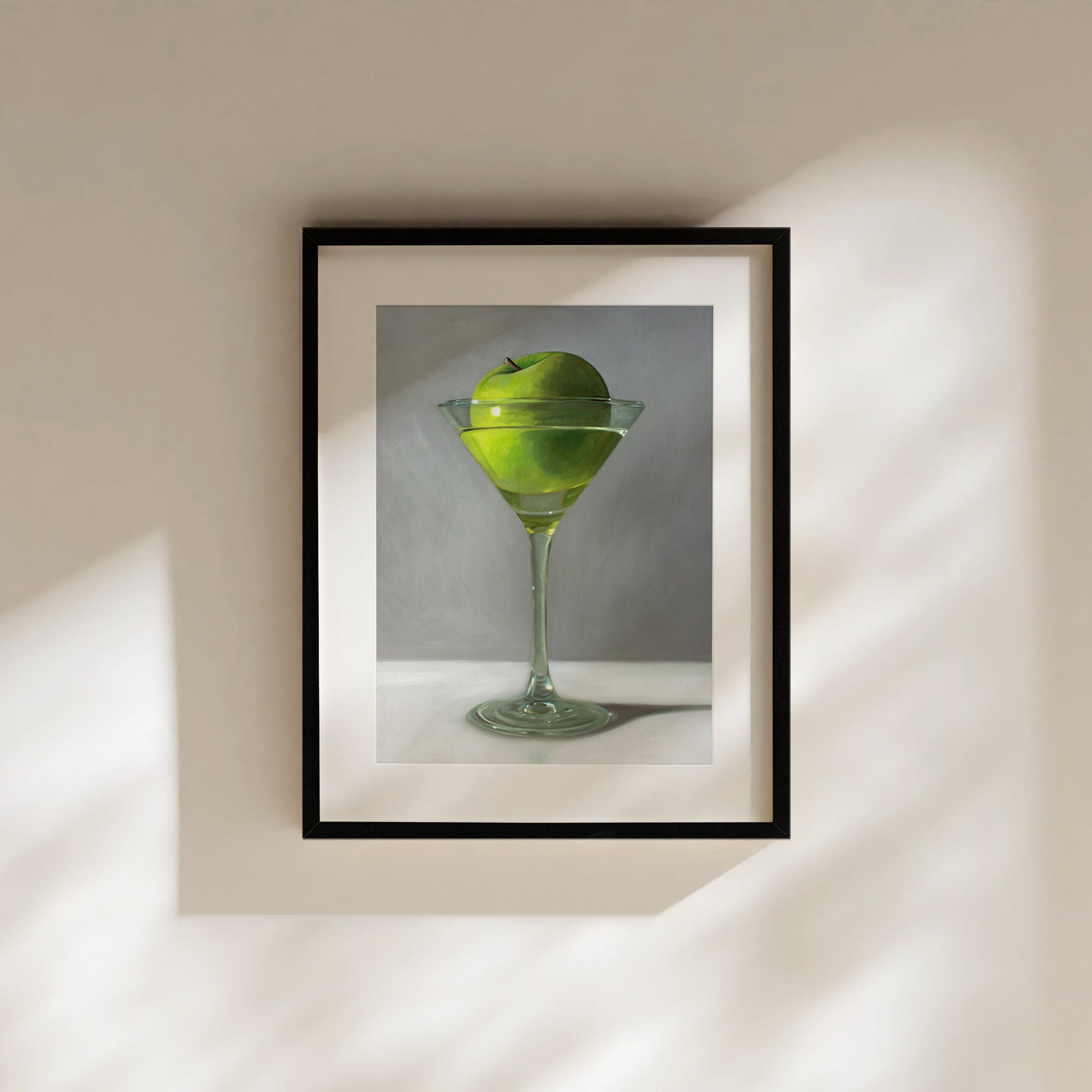 Framed fine art print of a vibrant green apple floating in a martini glass.