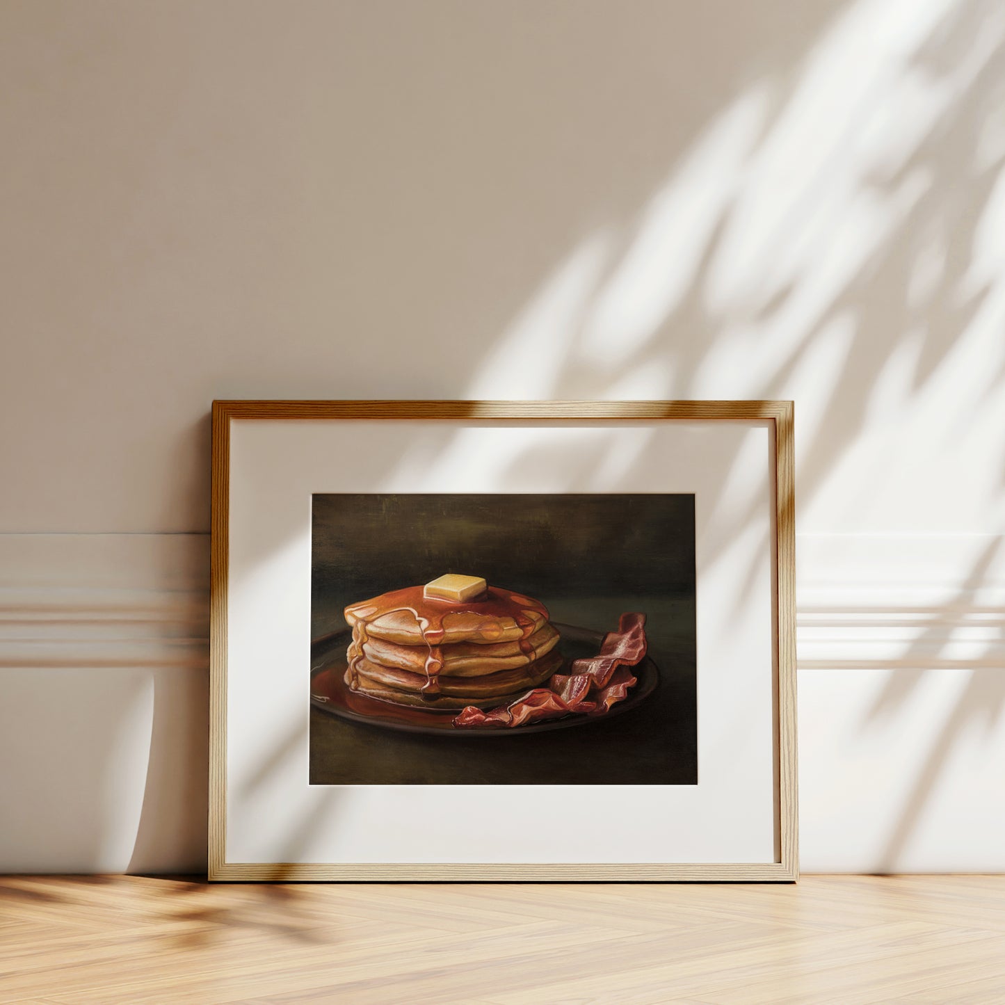 Bacon & Pancakes Fine Art Print by Lauren Pretorius: a stack of pancakes with butter and syrup resting on a plate, there are a couple of slices of bacon off to the right.