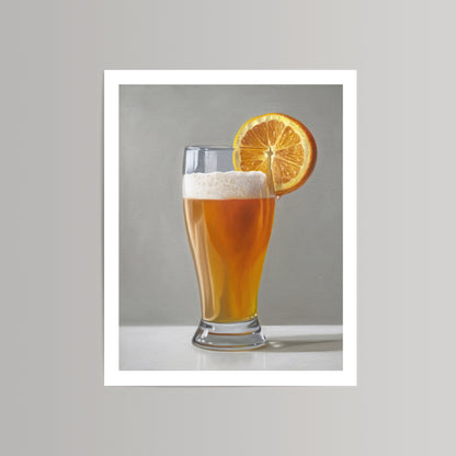 Fine art print of a golden beer shandy with a frothy head and an orange slice on a light gray background.