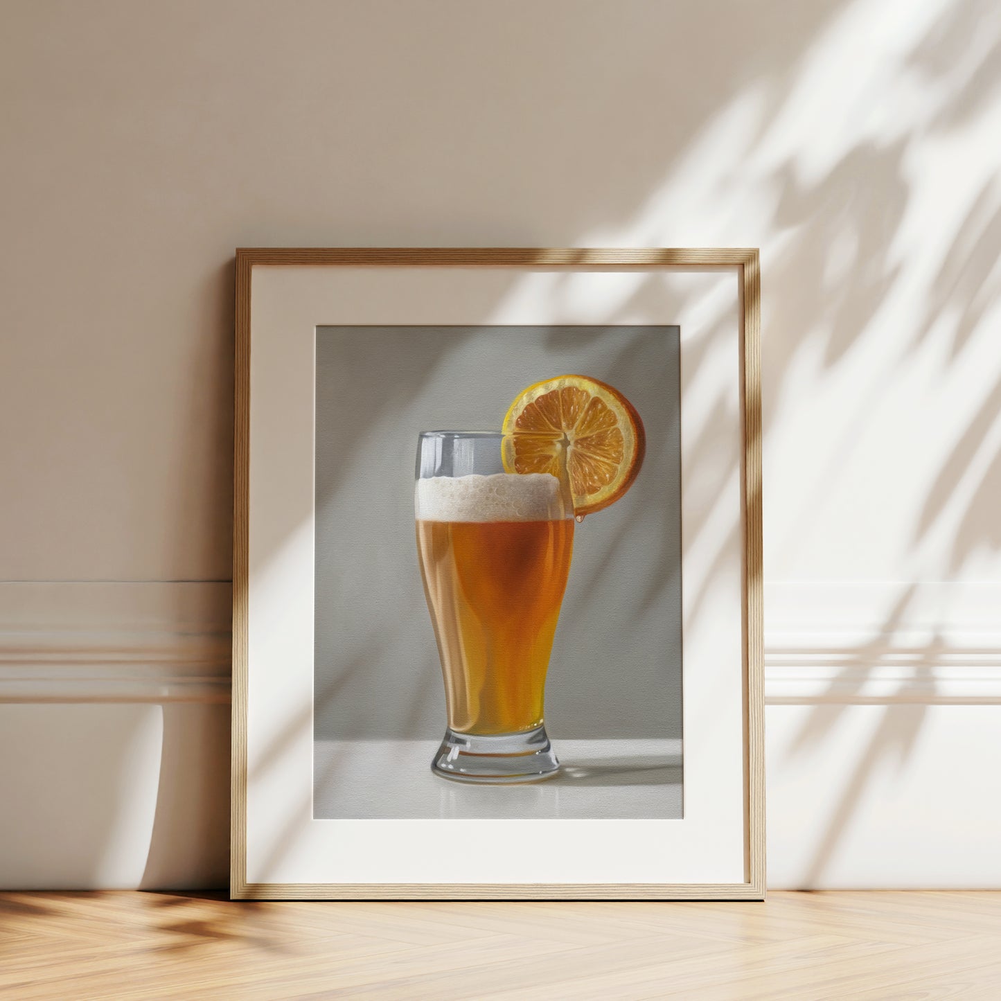 Framed fine art print of a golden beer shandy with an orange slice, on a light background.