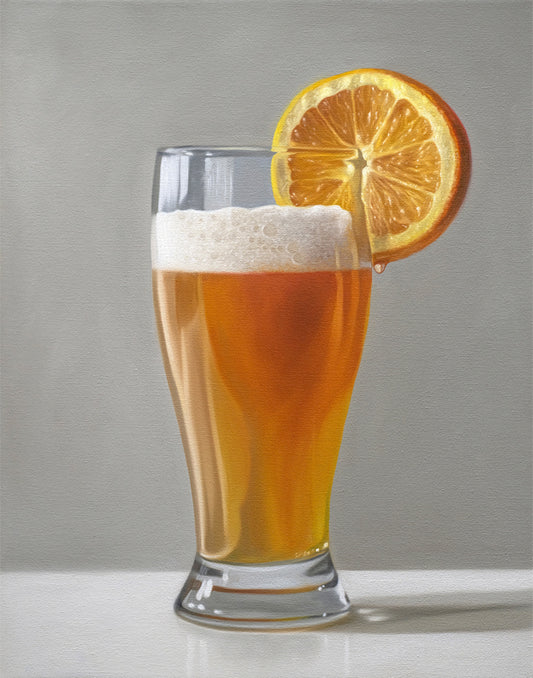 Realistic fine art print of a golden beer shandy in a glass, garnished with a bright orange slice.