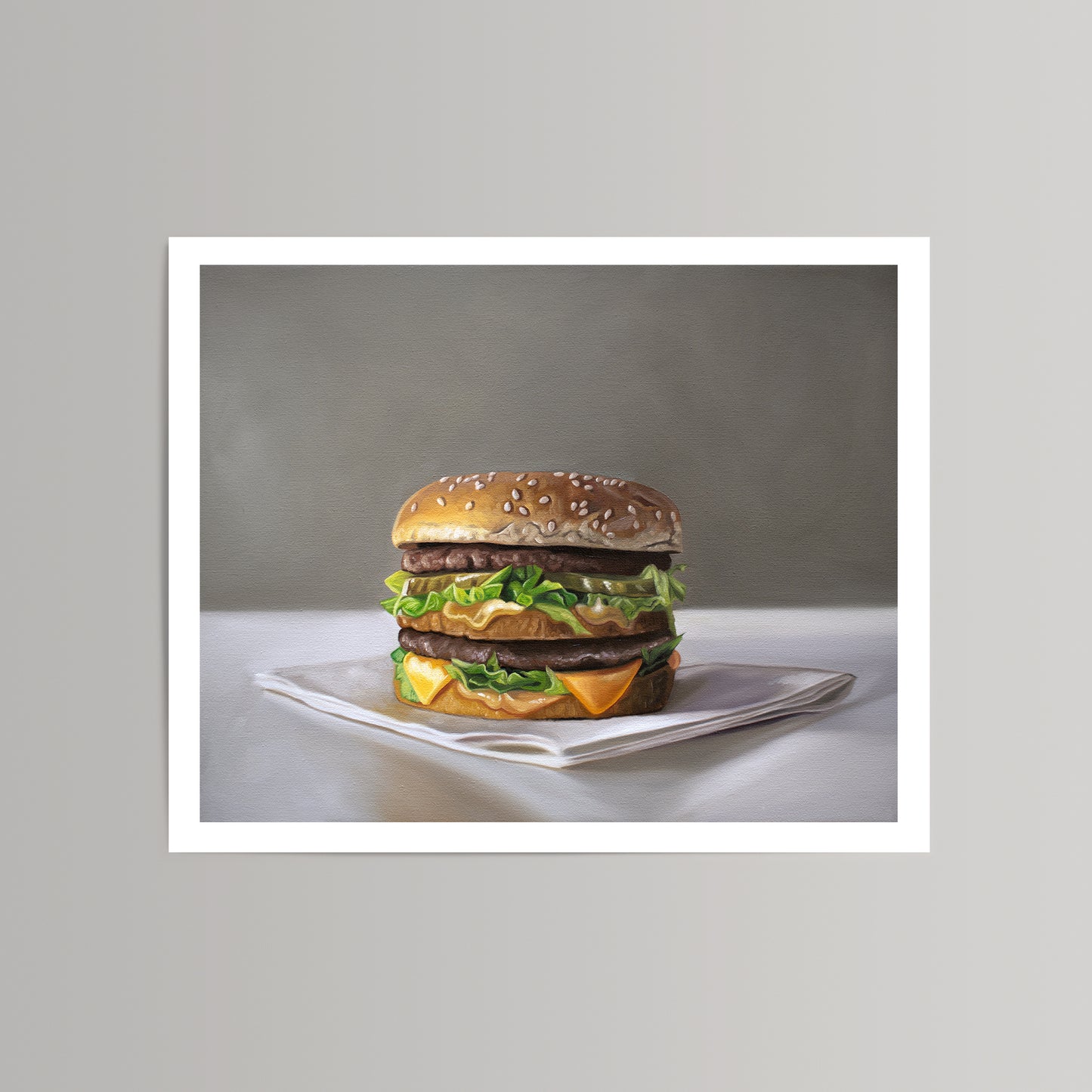 Realistic fine art print of a Big Mac burger on a white napkin, against a gray background.