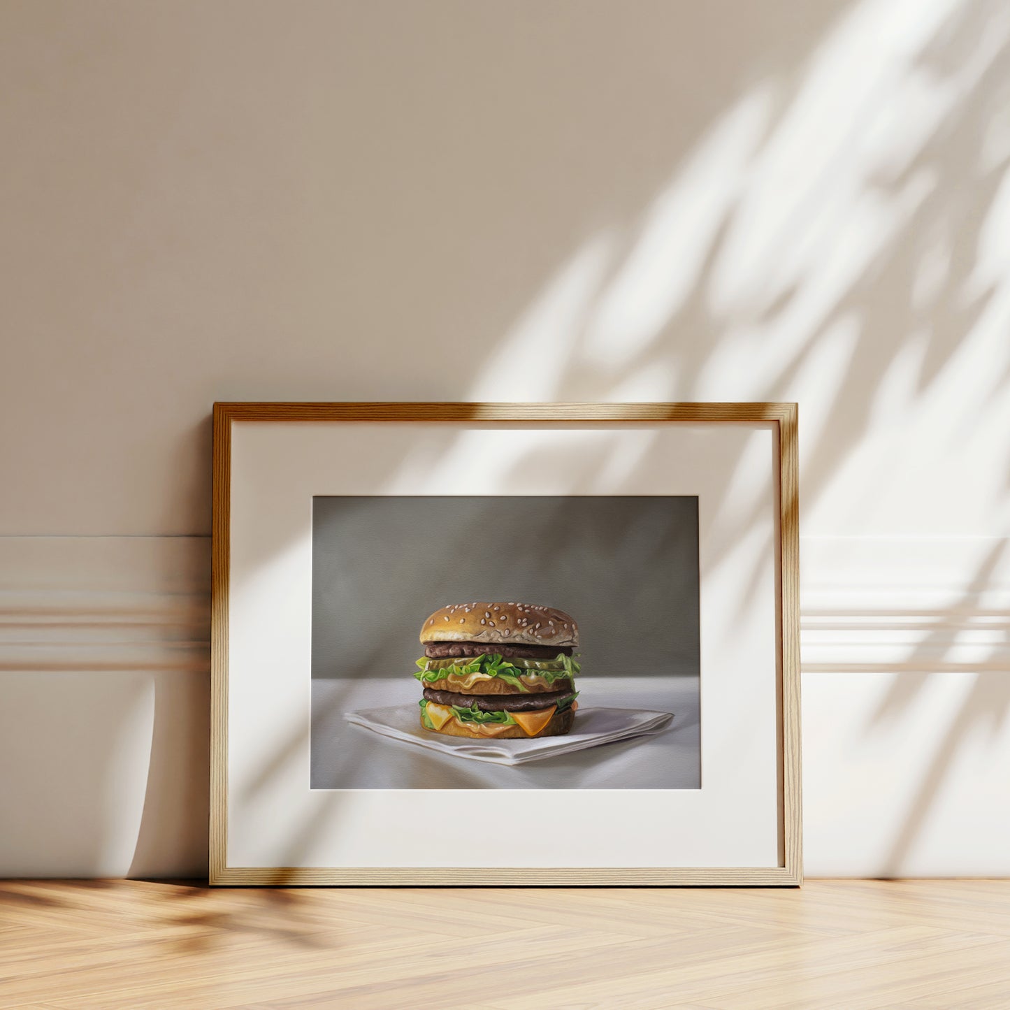 Framed fine art print of a Big Mac burger on museum-grade paper, displayed on a wooden surface.