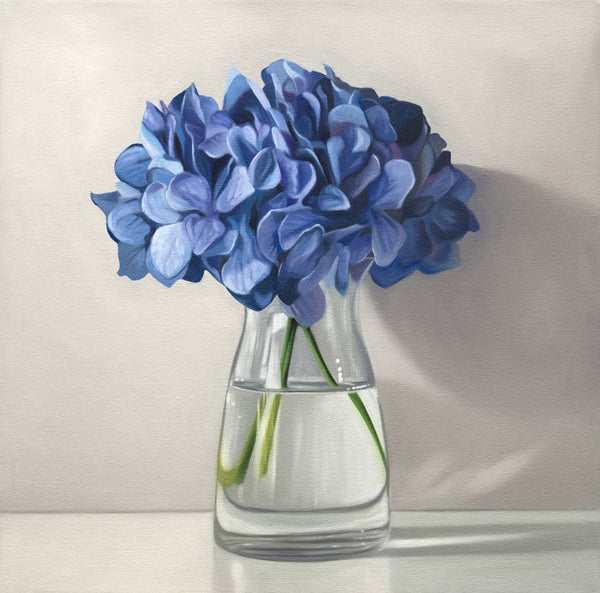 Clear glass vase with blue hydrangeas on a light background