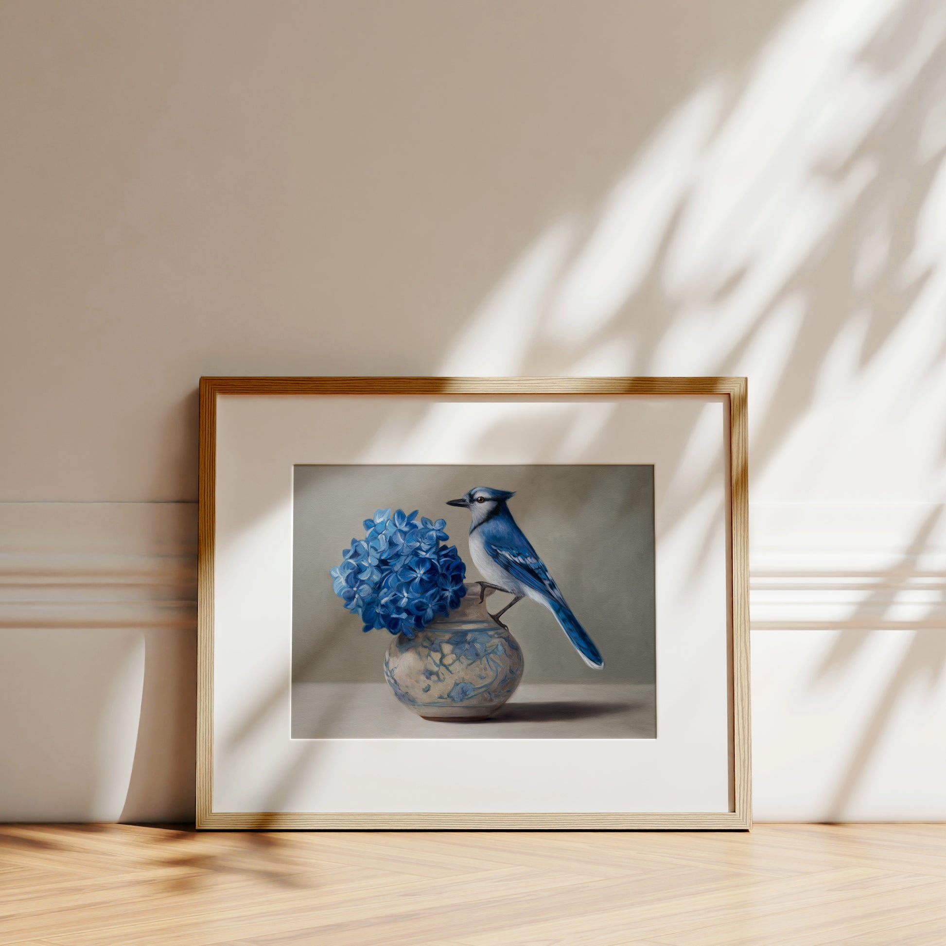 Blue Jay & Hydrangeas Fine Art Print by Lauren Pretorius: a Blue jay perched on a vase with blue hydrangea flowers against a neutral background