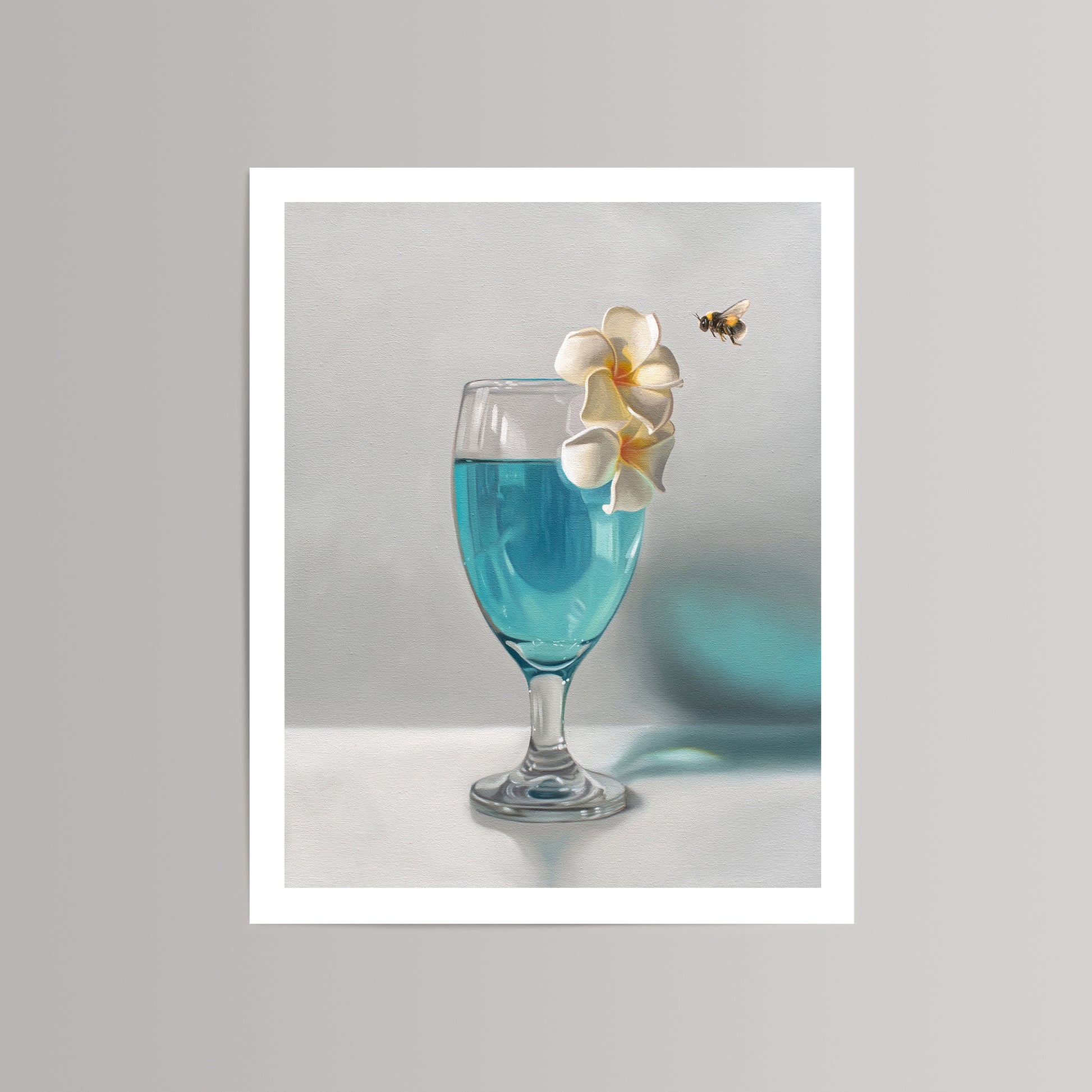 Fine art print of a blue drink in a glass with white plumeria flowers and a bumble bee.