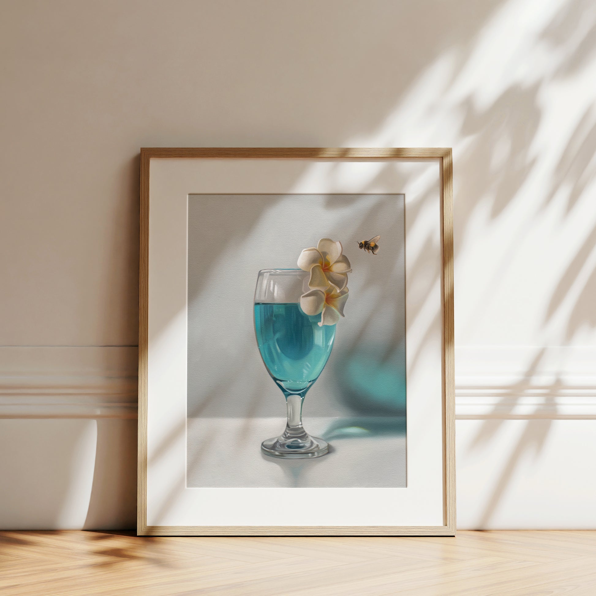 Framed fine art print of a blue drink with white plumeria flowers and a bumblebee.