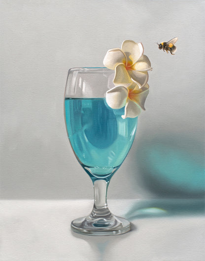 Fine art print of a glass with blue liquid, two white plumeria flowers, and a bumblebee.